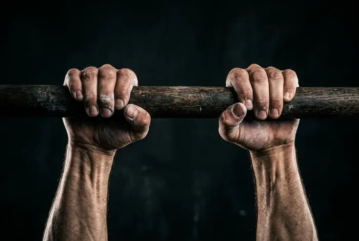 Alternative traction sans matériel pour renforcer le dos Gros plan sur des mains musclées saisissant une barre