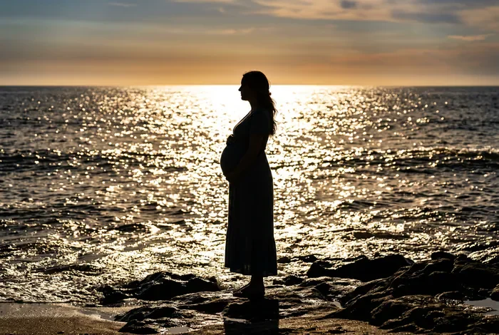 Peut on faire du bateau enceinte : conseils et précautions Silhouette d'une femme enceinte face à l'horizon marin