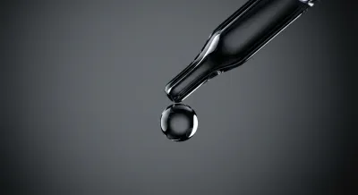 Goutte d'eau pure et cristalline illustrant la précision du soin.