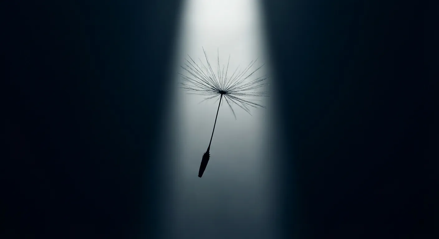 Gros plan iconique d'une graine de pissenlit lumineuse sur fond sombre.