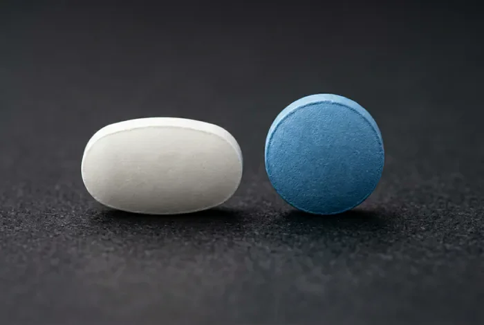 Différence entre Stagid 700 et Metformine 500 expliquée Gros plan minimaliste de deux médicaments différents sur fond gris