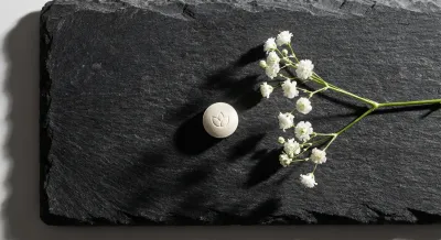 Vue minimaliste d'un comprimé et d'une fleur évoquant la santé et la féminité