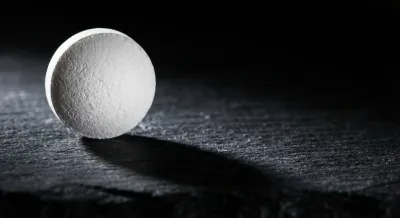 Gros plan d'un comprimé de lormétazépam sur fond sombre