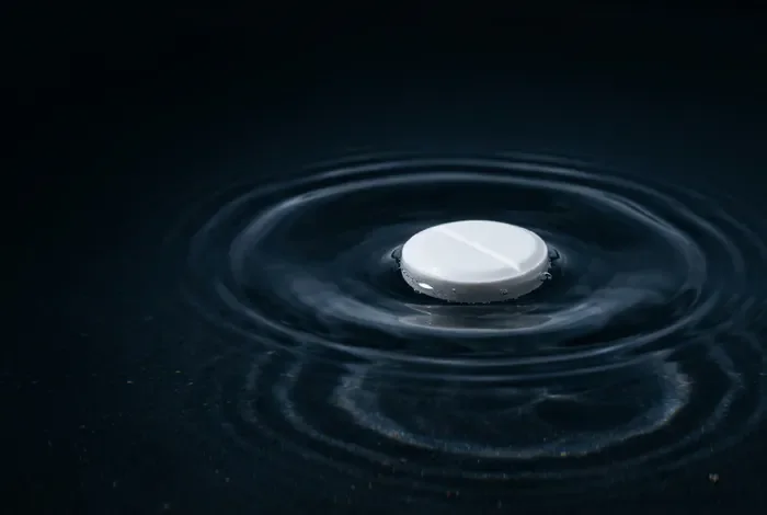 Est-ce que la pilule Zoely est dangereuse ? Analyse des risques Gros plan minimaliste d'une pilule dans l'eau