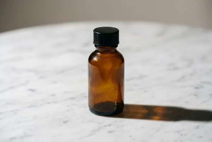Flacon pharmaceutique en verre ambré sur fond minimaliste
