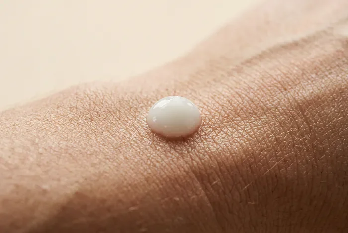 Vue macro minimaliste d'une crème cicatrisante sur une peau tatouée