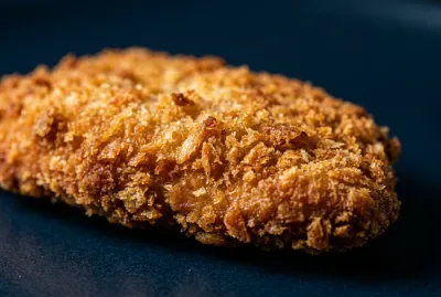 Gros plan minimaliste sur la texture croustillante d'un cordon bleu