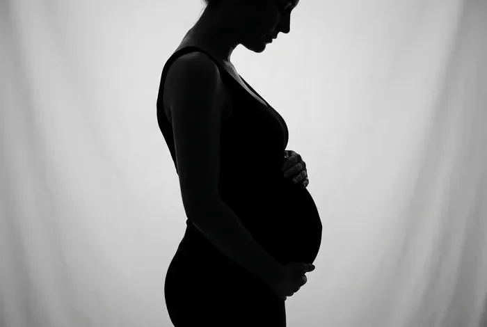 Être enceinte en période d'essai CDI : vos droits en 2026 Silouhette élégante d'une femme enceinte en milieu professionnel