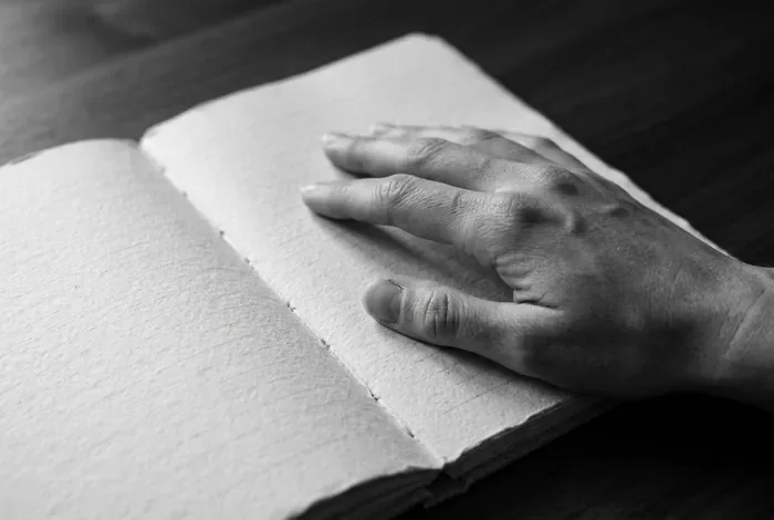 Prix seance EMDR en 2026 : tarifs moyens des praticiens Main posée sur un journal, symbole de travail thérapeutique