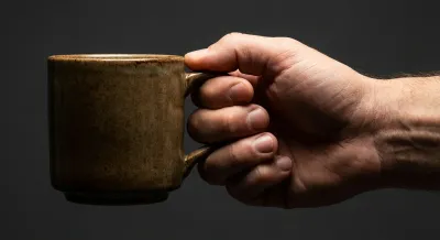 Gros plan d'une main stable tenant une tasse, illustrant la force retrouvée.