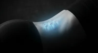 Gros plan artistique de la zone lombaire L5-S1 soulignée par une lumière bleue